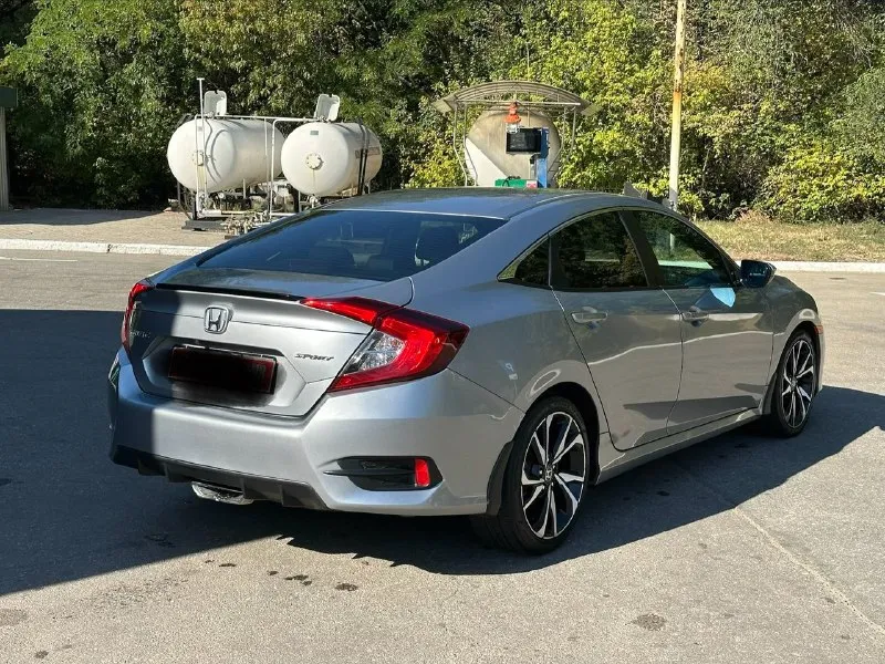 Продается honda civic 2.0 sport (2019), идеальное состояние цена 1🍋980 тыс. руб, торг. год выпуска: 2019 пробег: 60 000 км (оригинальный) двигатель: 2.0 л, атмосферный трансмиссия: вариатор привод: передний расход топлива: 7-8 л/100 км honda civic 2.0 sport 2019 года выпуска в безупречном состоянии. автомобиль был лично пригнан из сша в 2021 году и эксплуатировался бережно, преимущественно в летний период. хранился на обогреваемом паркинге. оригинальный пробег составляет всего 60 000 км, что подтверждается отличным техническим состоянием. преимущества: * надежный двигатель: атмосферный двигатель 2.0 известен своим ресурсом более 500 000 км и обеспечивает оптимальный баланс экономичности и динамики. регулярное обслуживание с заменой масла каждые 6 000 км гарантирует его долговечную работу. * идеальное состояние кузова: автомобиль не имеет повреждений и находится в отличном внешнем виде. * комплектация sport: спортивный обвес, 18-дюймовые литые диски и спортивная подвеска 📞 звоните: +7(949)3121414 - фотография - 2