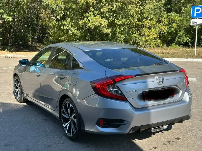 Продается honda civic 2.0 sport (2019), идеальное состояние цена 1🍋980 тыс. руб, торг. год выпуска: 2019 пробег: 60 000 км (оригинальный) двигатель: 2.0 л, атмосферный трансмиссия: вариатор привод: передний расход топлива: 7-8 л/100 км honda civic 2.0 sport 2019 года выпуска в безупречном состоянии. автомобиль был лично пригнан из сша в 2021 году и эксплуатировался бережно, преимущественно в летний период. хранился на обогреваемом паркинге. оригинальный пробег составляет всего 60 000 км, что подтверждается отличным техническим состоянием. преимущества: * надежный двигатель: атмосферный двигатель 2.0 известен своим ресурсом более 500 000 км и обеспечивает оптимальный баланс экономичности и динамики. регулярное обслуживание с заменой масла каждые 6 000 км гарантирует его долговечную работу. * идеальное состояние кузова: автомобиль не имеет повреждений и находится в отличном внешнем виде. * комплектация sport: спортивный обвес, 18-дюймовые литые диски и спортивная подвеска 📞 звоните: +7(949)3121414 - фотография - 6