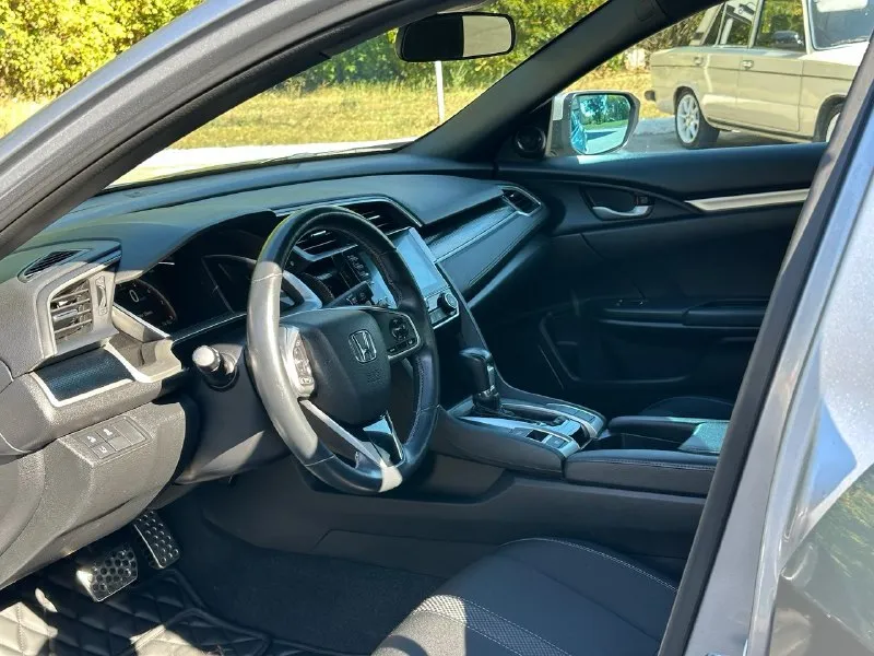 Продается honda civic 2.0 sport (2019), идеальное состояние цена 1🍋980 тыс. руб, торг. год выпуска: 2019 пробег: 60 000 км (оригинальный) двигатель: 2.0 л, атмосферный трансмиссия: вариатор привод: передний расход топлива: 7-8 л/100 км honda civic 2.0 sport 2019 года выпуска в безупречном состоянии. автомобиль был лично пригнан из сша в 2021 году и эксплуатировался бережно, преимущественно в летний период. хранился на обогреваемом паркинге. оригинальный пробег составляет всего 60 000 км, что подтверждается отличным техническим состоянием. преимущества: * надежный двигатель: атмосферный двигатель 2.0 известен своим ресурсом более 500 000 км и обеспечивает оптимальный баланс экономичности и динамики. регулярное обслуживание с заменой масла каждые 6 000 км гарантирует его долговечную работу. * идеальное состояние кузова: автомобиль не имеет повреждений и находится в отличном внешнем виде. * комплектация sport: спортивный обвес, 18-дюймовые литые диски и спортивная подвеска 📞 звоните: +7(949)3121414 - фотография - 9