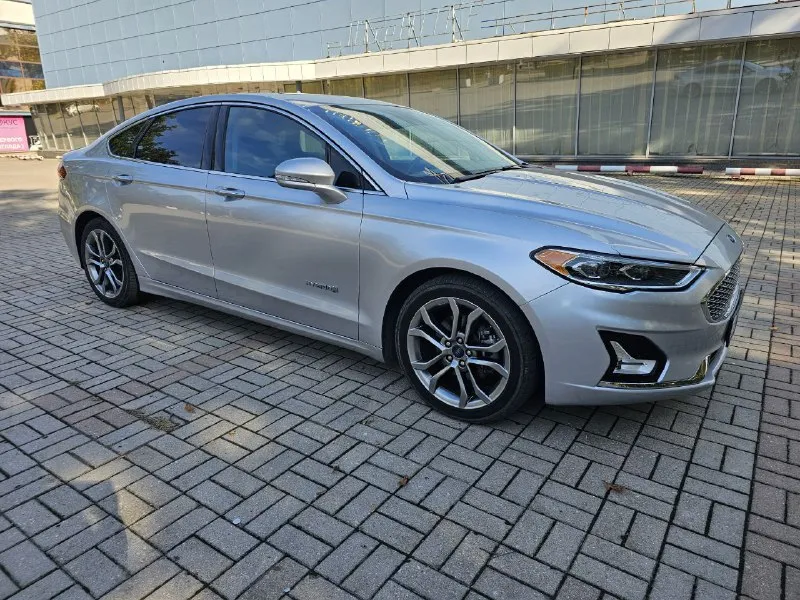 Ford fusion hybrid 2019 titanium (usa) американский mondeo в топовой комплектации! пробег 99 800 км 🔋 гибрид — расход 5–6 л/100 км, на баке до 900 км пробега. 🔧 полностью обслужен, без сюрпризов. 💪надёжный — такие фьюжены в сша проходят 500 000+ км без проблем. ❗первый владелец в рф, подбирал и пригонял под себя. 💎 titanium: адаптивный круиз, удержание в полосе, автоторможение, контроль слепых зон, full led фары, камера, парктроники, кожа, вентиляция и подогрев сидений, подогрев руля, аудио sony, бесключевой доступ, дистанционный запуск, кодовый вход, настраиваемая подсветка, еврозеркала (!) с широким обзором и складыванием. 📌 пробег оригинальный, любая проверка. 💬 без посредников. 📍 осмотр и тест-драйв в донецке 💸 1 890 000 ₽ +79494710689 - фотография - 2