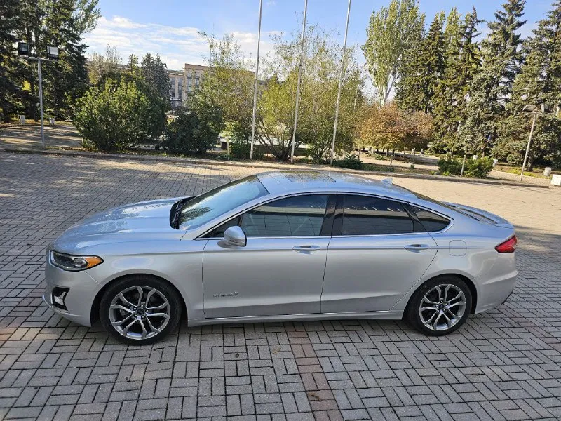 Ford fusion hybrid 2019 titanium (usa) американский mondeo в топовой комплектации! пробег 99 800 км 🔋 гибрид — расход 5–6 л/100 км, на баке до 900 км пробега. 🔧 полностью обслужен, без сюрпризов. 💪надёжный — такие фьюжены в сша проходят 500 000+ км без проблем. ❗первый владелец в рф, подбирал и пригонял под себя. 💎 titanium: адаптивный круиз, удержание в полосе, автоторможение, контроль слепых зон, full led фары, камера, парктроники, кожа, вентиляция и подогрев сидений, подогрев руля, аудио sony, бесключевой доступ, дистанционный запуск, кодовый вход, настраиваемая подсветка, еврозеркала (!) с широким обзором и складыванием. 📌 пробег оригинальный, любая проверка. 💬 без посредников. 📍 осмотр и тест-драйв в донецке 💸 1 890 000 ₽ +79494710689 - фотография - 5