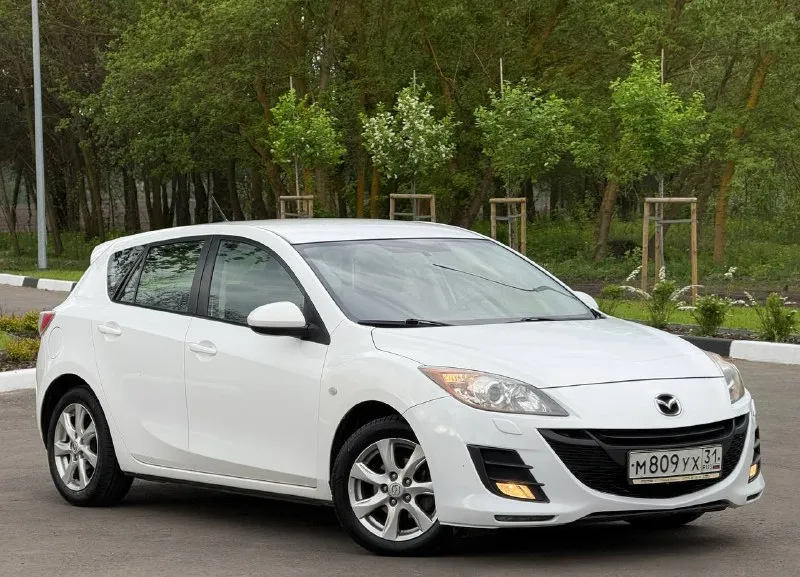 В продаже mazda 3, 2010 г. в, 1.6 л, 105 л. с, мкпп. пробег : 201,800 км. один собственник с 2010 г. обслуживалась исключительно на дилере, есть отметки в сервисной книге. цвет - crystal white pearl с “перламутровыми“ частицами, изменяет свой оттенок в зависимости от угла освещения. кузов без следов коррозии, соответствует фото. москвы / питера не видела, весь период была в белгороде. днище / пороги - на отлично. арки и низа дверей целые. двс работает едва слышно, никаких нареканий и ошибок. мкпп на отлично. салон сохранился достойно, сиденья как новые. комплектация - двухзонный климат с круизом, датчик дождя / света, мультируль, складывание зеркал, подогревы сидений, зеркал и лобового, штатный парктроник, омыватель оптики, линзы, датчики ebd, bas, abs, esp и прочие навороты. стоит автозапуск, два родных ключа и т. д и т. п. техосмотр пройден, авто готово к оформлению. цена - 720.000 рублей. рассрочки и обмена нет. территориально находится в г макеевка (центр) контакты : +7(949)003-33-27, +7(979)028-27-27 мессенджер telegram и max есть на первом тел. - фотография - 5